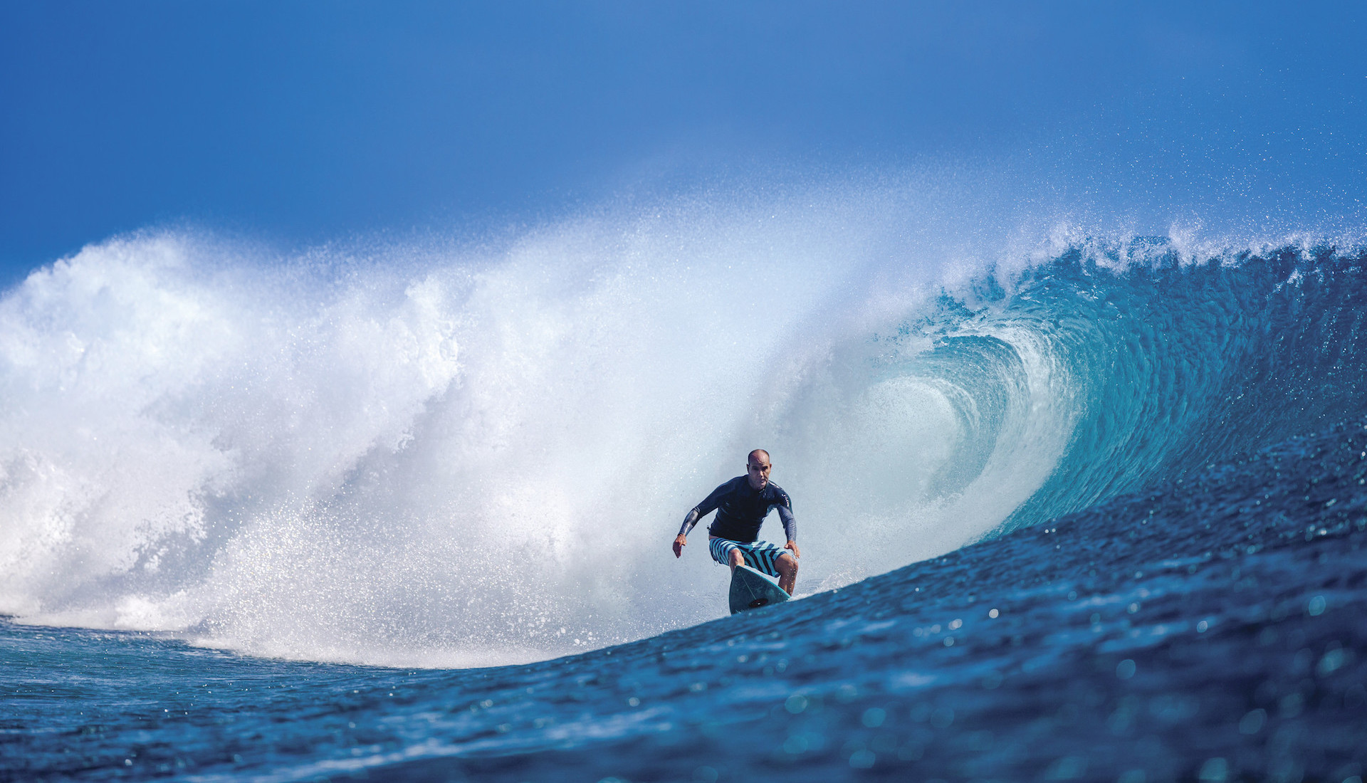 Lone surfer exiting barrel at Cloudbreak in Fiji