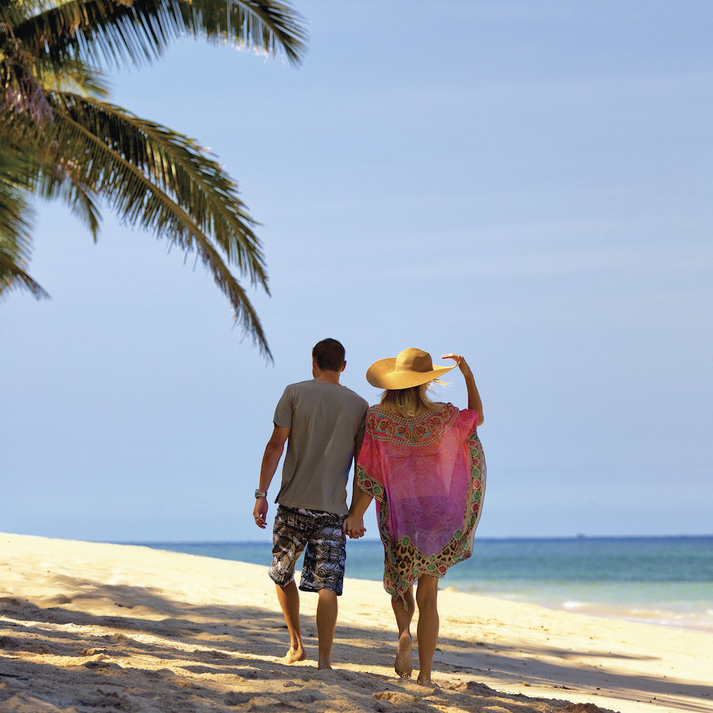 Honeymoon couple walking on beach in Fiji 