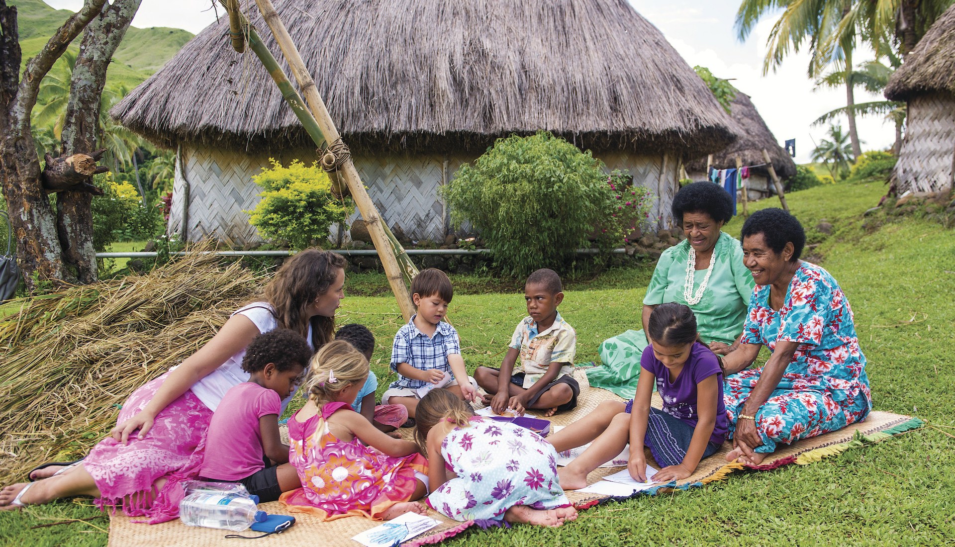 Children colouring with fijian ladies